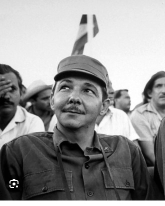 Black-and-white portrait of a uniformed man in a cap looking up above a crowd