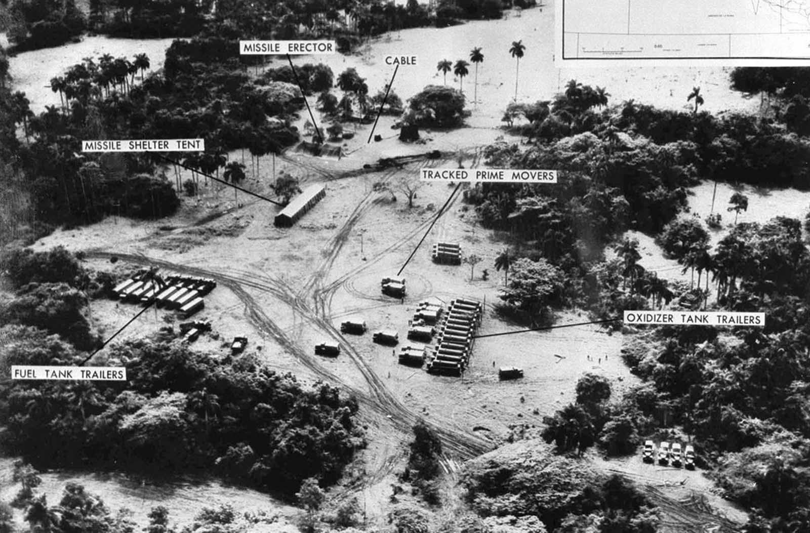 Annotated aerial reconnaissance photograph of a wooded military camp with missile equipment labelled in English